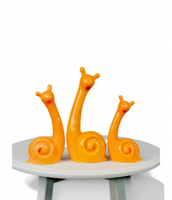Bright Orange Ceramic Snail Family – Modern Art Figurine Set Each snail is handmade by skilled artisans, featuring a modern, minimalist shape that pairs beautifully with contemporary interiors. The bright orange hue and fluid design make them ideal for display on consoles, shelves, or tabletops — perfect for adding a touch of whimsy and personality to your décor. Whether styled together as a family set or separately in different spaces, these ceramic pieces are sure to spark joy and conversation. Features: Set of 3 handcrafted ceramic snail figurines Glossy orange finish with smooth detailing Perfect for modern or playful home décor Ideal for gifting or adding a pop of color to interiors Handcrafted by DNF Ceramics artisans