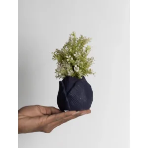 The Midnight Fold Mini Planter is a refined ceramic piece designed for lovers of minimal yet artistic décor. Featuring a softly rounded silhouette with subtle folded texture detailing, this planter creates a sophisticated sculptural presence despite its compact size. The rich midnight blue matte finish adds depth and modern elegance, making it perfect for contemporary interiors. Its organic folded pattern gives it a handcrafted aesthetic while maintaining a clean, minimal appeal. Midnight Fold Mini Planter